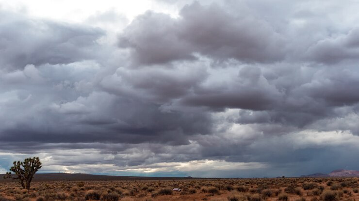 Large, stormy cumulus rain clouds take shape over the Mojave Desert wilderness - time lapse