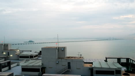 Vista-Sobre-Un-Edificio-Alto-Hacia-El-Mar-Con-Un-Gran-Puente-En-Penang-Malasia