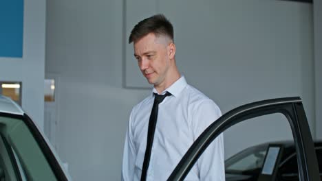 man looking at a car in a dealership