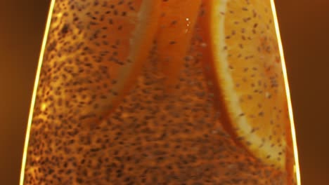 chia seeds blending and rotating in water with lemon, orange close-up macro yellow orang background. dry healthy ingredient. healthy superfood rich in omega 3 fatty acids. salvia hispanica