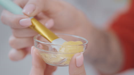 applying face mask with gold brush