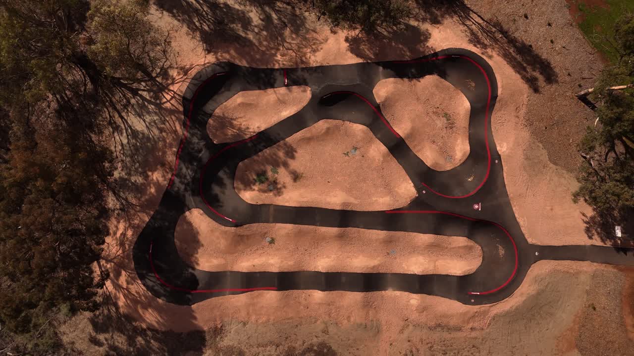 Top down of dry earth bmx pump track paved fresh in dessert and cracked soil textures shaped by nature, nobody