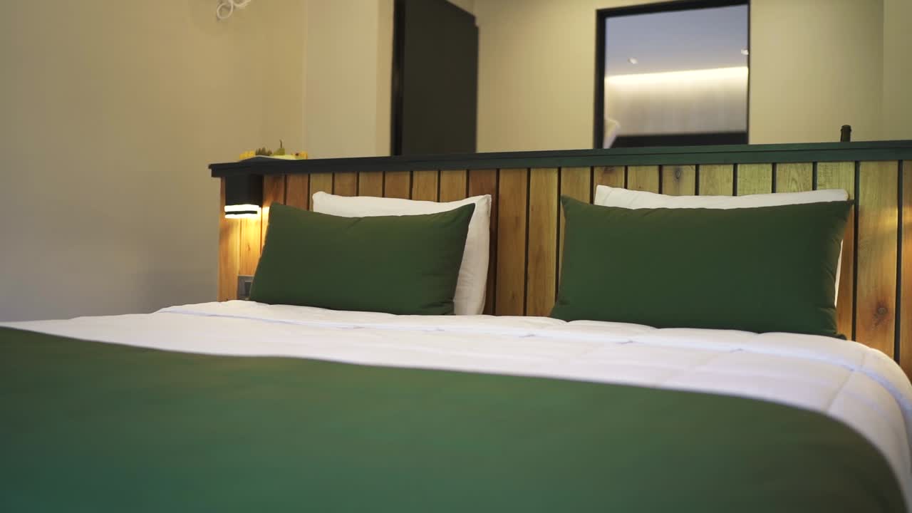 Panning view of a tidy empty vintage hotel room twin bed with nobody, no people