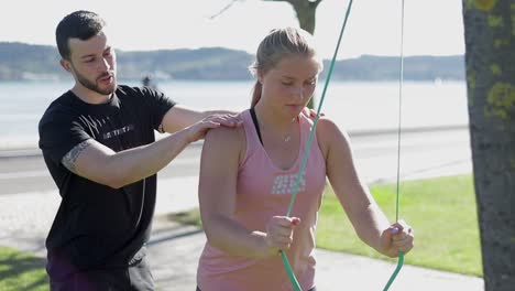 Concentrated-sportswoman-training-with-instructor-in-park.