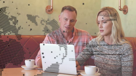 animation of global network and data over caucasian male and female colleague using laptop at cafe