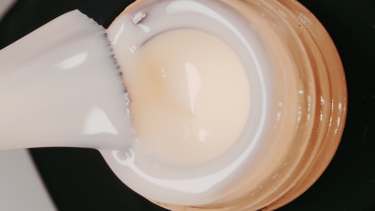 Close-up of nail gel polish pouring into a container