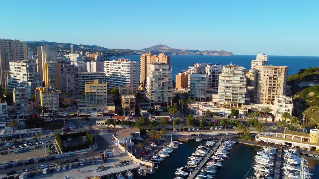 clip cinematográfico de drones giratorios sobre un puerto deportivo de yates con hoteles y resorts en el fondo en la ciudad costera de calpe en españa