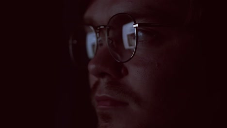 close-up of a man wearing glasses at night