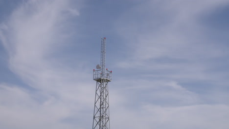 telecommunication tower against a cloudy sky
