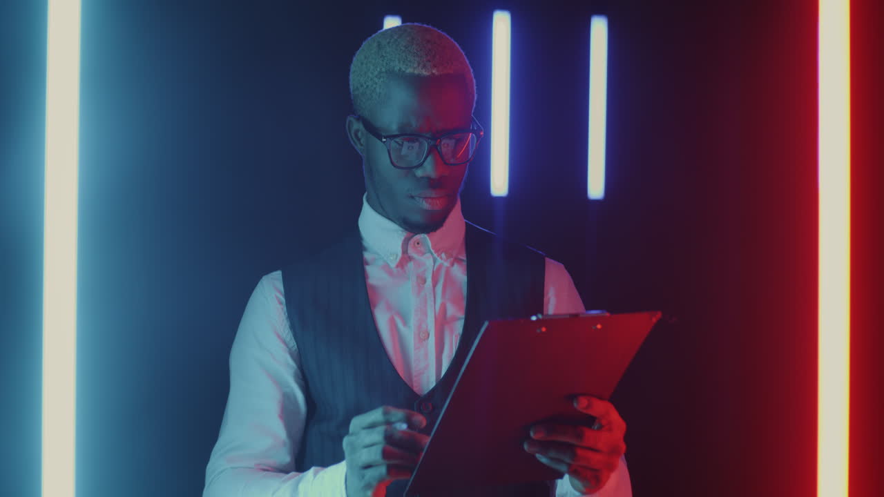 Businessman analyzing report under neon lights