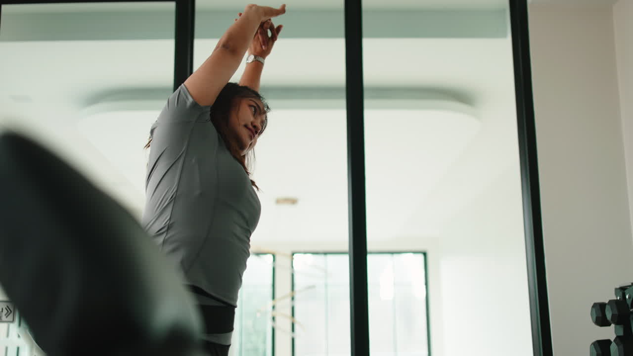 mujer estirándose en el gimnasio