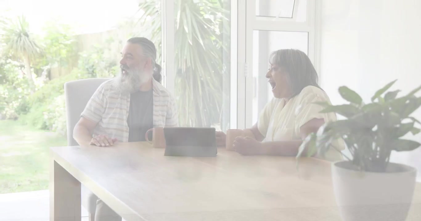 Couple discussing tech at table, tablet; glitches crossing frames, guest entering causing greeting