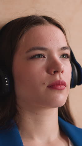 woman with headphones listens to music in library closeup. attractive brunette lady enjoys audiobook learning material at university. education technology