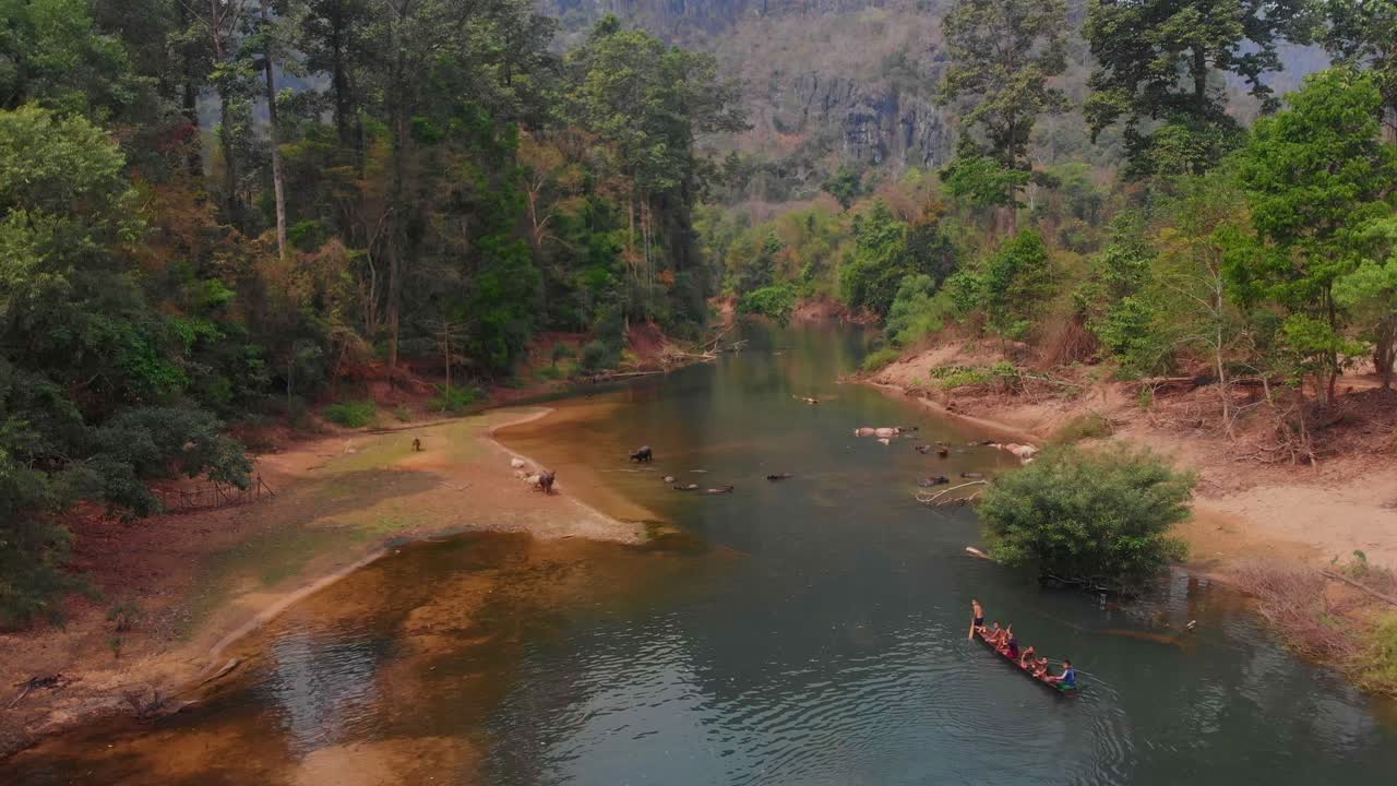 Bambini che pagaiano nel fiume alla Grotta di Kong Lor. Laos, Khammouane