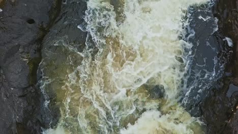 Corriente-De-Agua-Llena-Con-Espuma-Y-Rocas