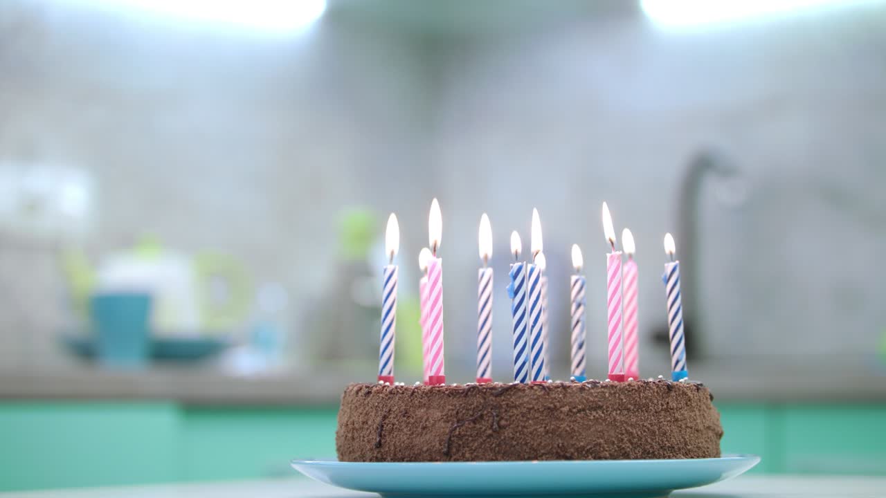 pastel de cumpleaños con velas llama en la cocina. postre de cumpleaños con velas