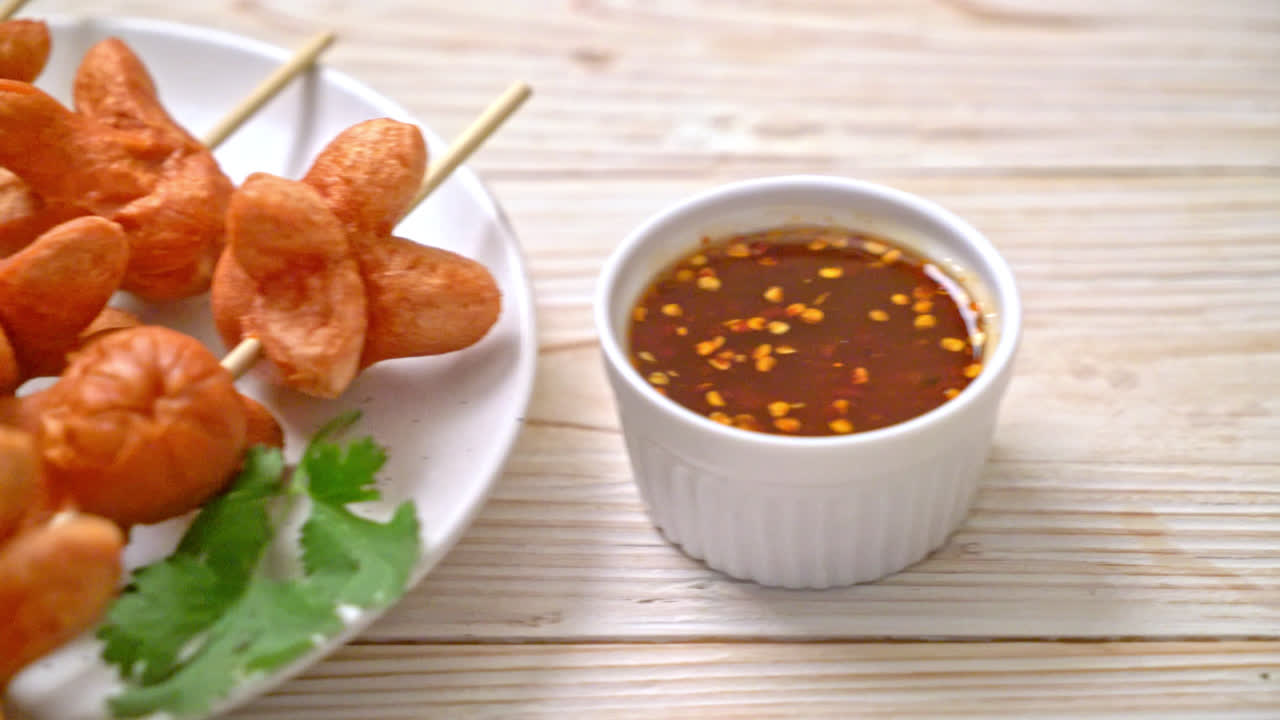 Brocheta de salchicha frita con salsa para mojar