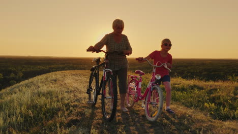 una anciana camina con su nieta en bicicleta al atardecer 3