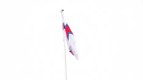 National-flag-of-Faroe-Islands-hanging-from-pole-stops-waving-in-wind-during-cloudy-day