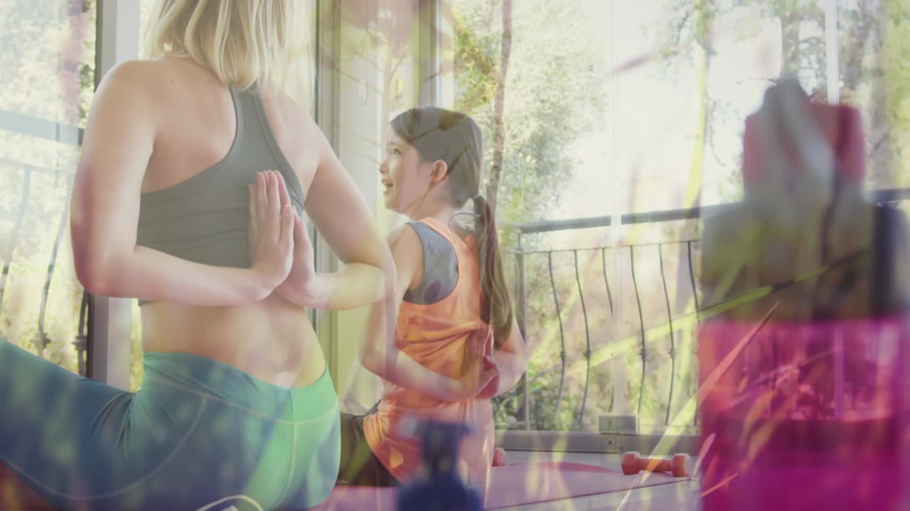 animación de hierba moviéndose sobre feliz mujer caucásica con su hija haciendo yoga