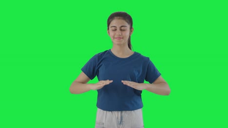 Happy-Indian-teenage-girl-doing-breathe-in-breathe-out-exercise-Green-screen