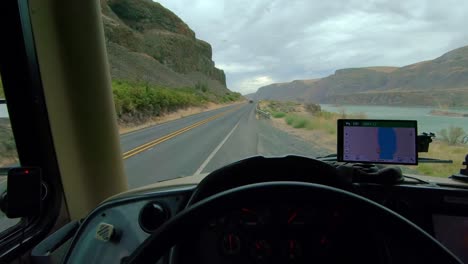 pov of the driver of a parked class a rv, point of view of lenore lake and highway 17 in washington state on a cloudy, windy day