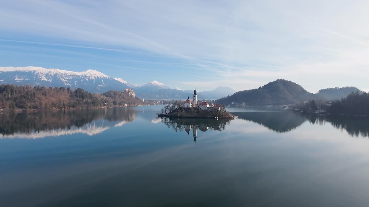 Vista di profilo della Chiesa di Bled e delle Alpi in Slovenia con riflesso.