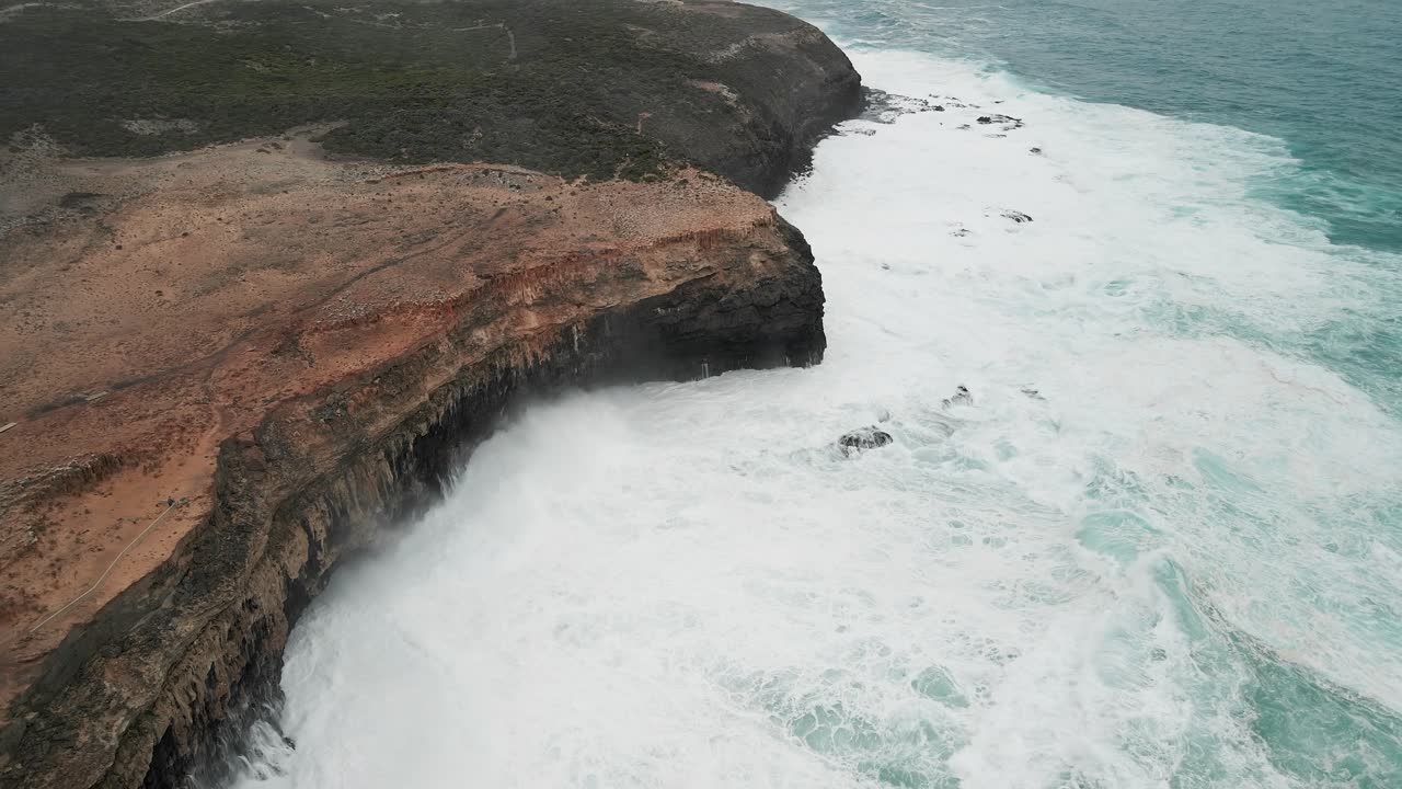 tilt down shot de las mareas altas golpeando la costa de cabo bridgewater, australia