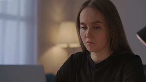 portrait of concentrated young woman working with laptop sending message and email work from home seo-specialist or smm-manager