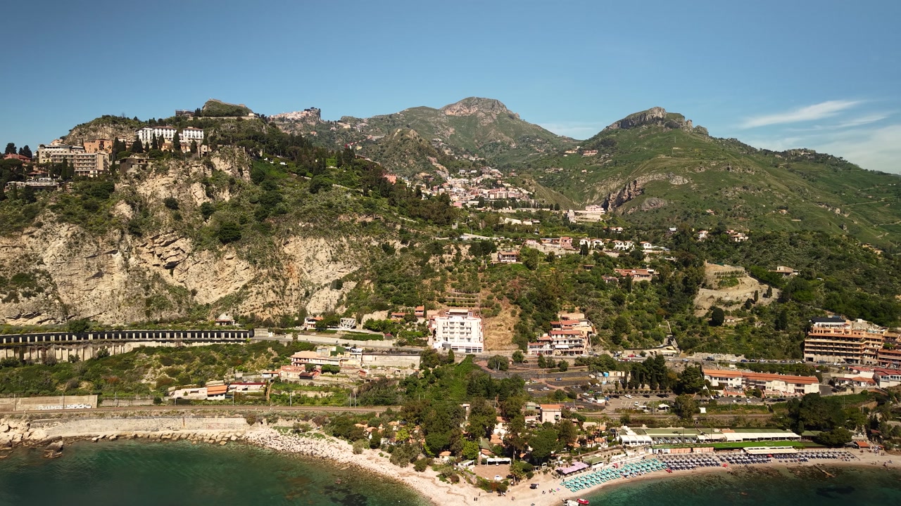 Aerial view towards sunny Isola Bella island idyllic resort beaches and paradise villa properties