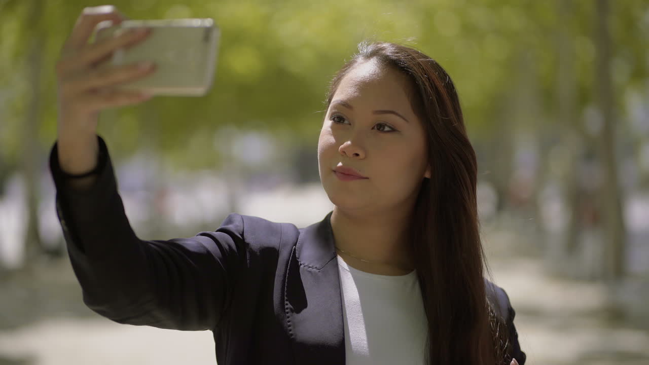 Attractive girl taking selfie with smartphone