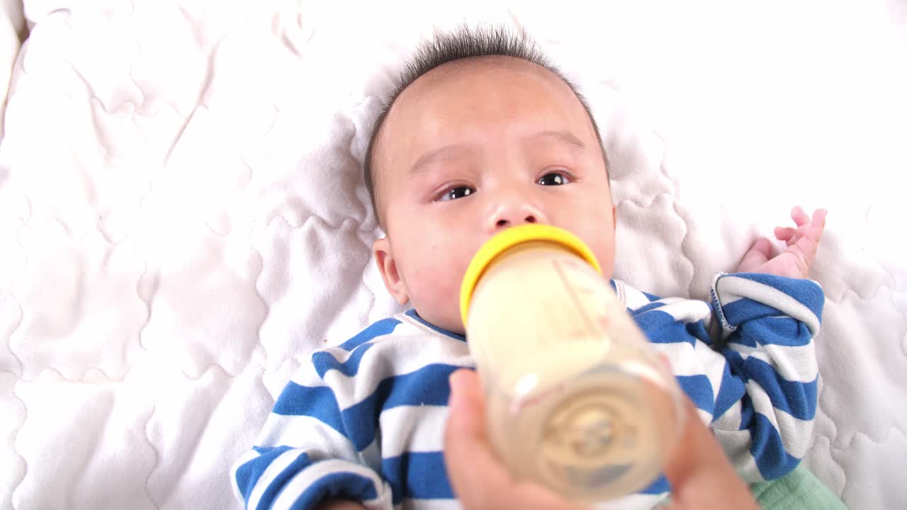 Newborn Baby Drinking Milk From A Bottle While Her Mom Hold, Video In 4K