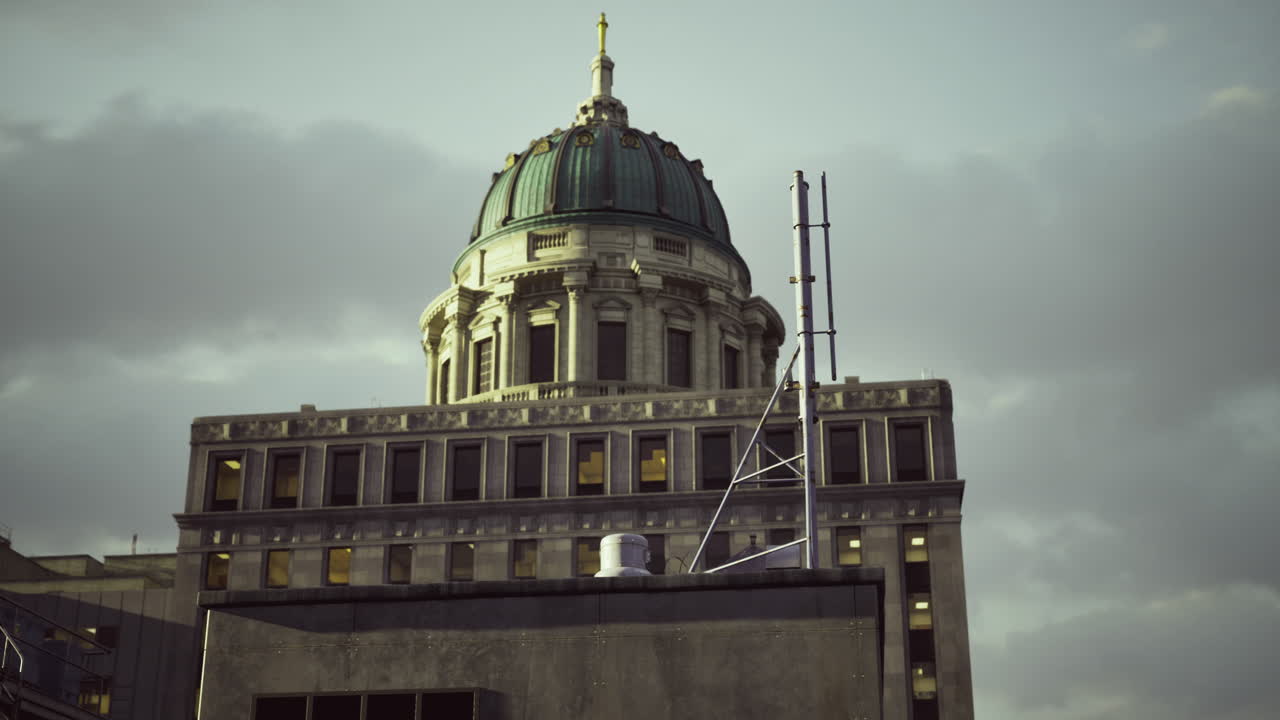 Historic building dome shines under cloudy sky in urban setting