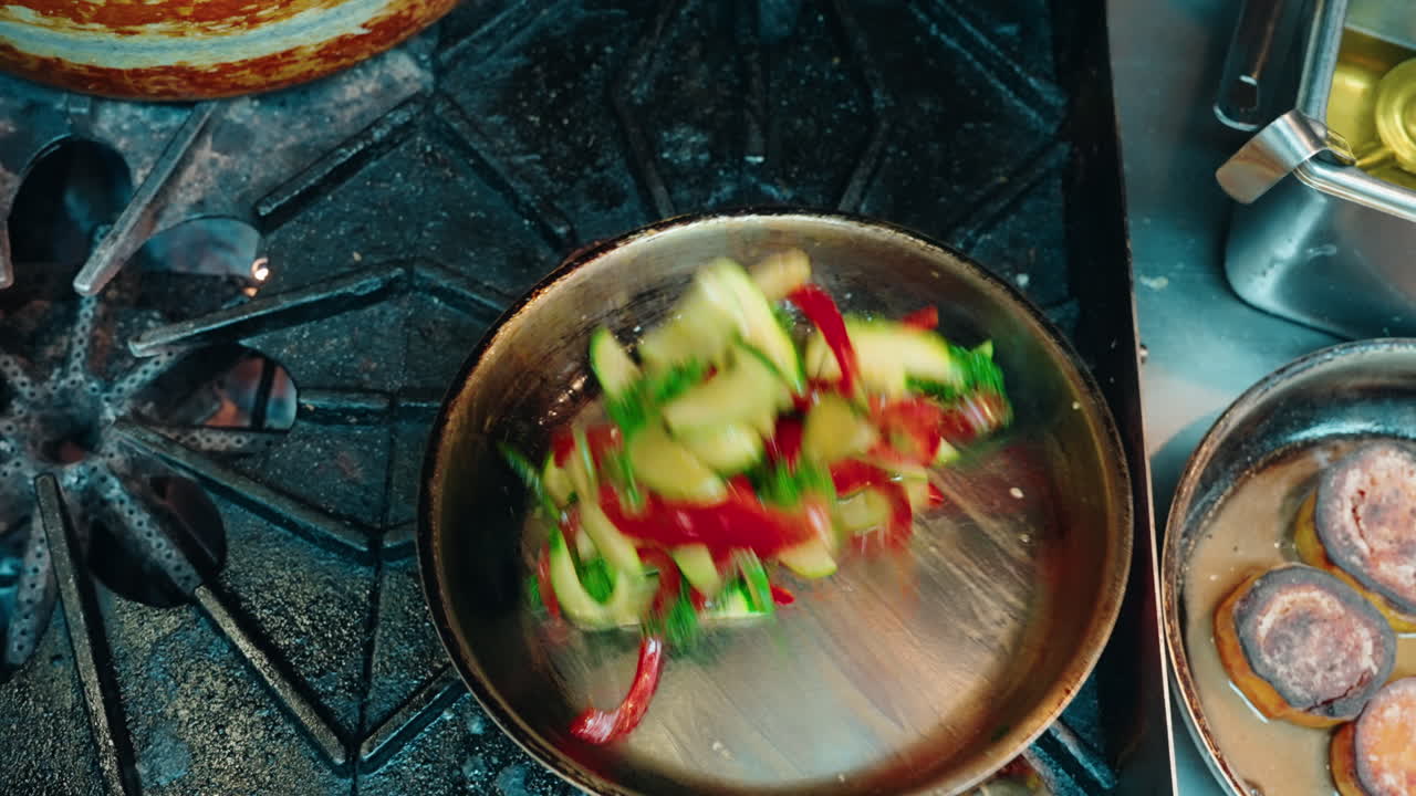 Close up slow motion of stir frying vegetables at the chef's kitchen.