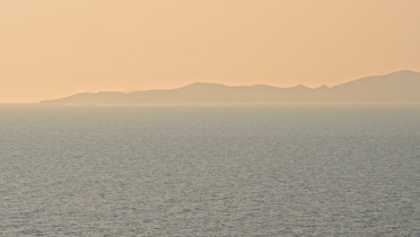 日落時的海景,背景是山