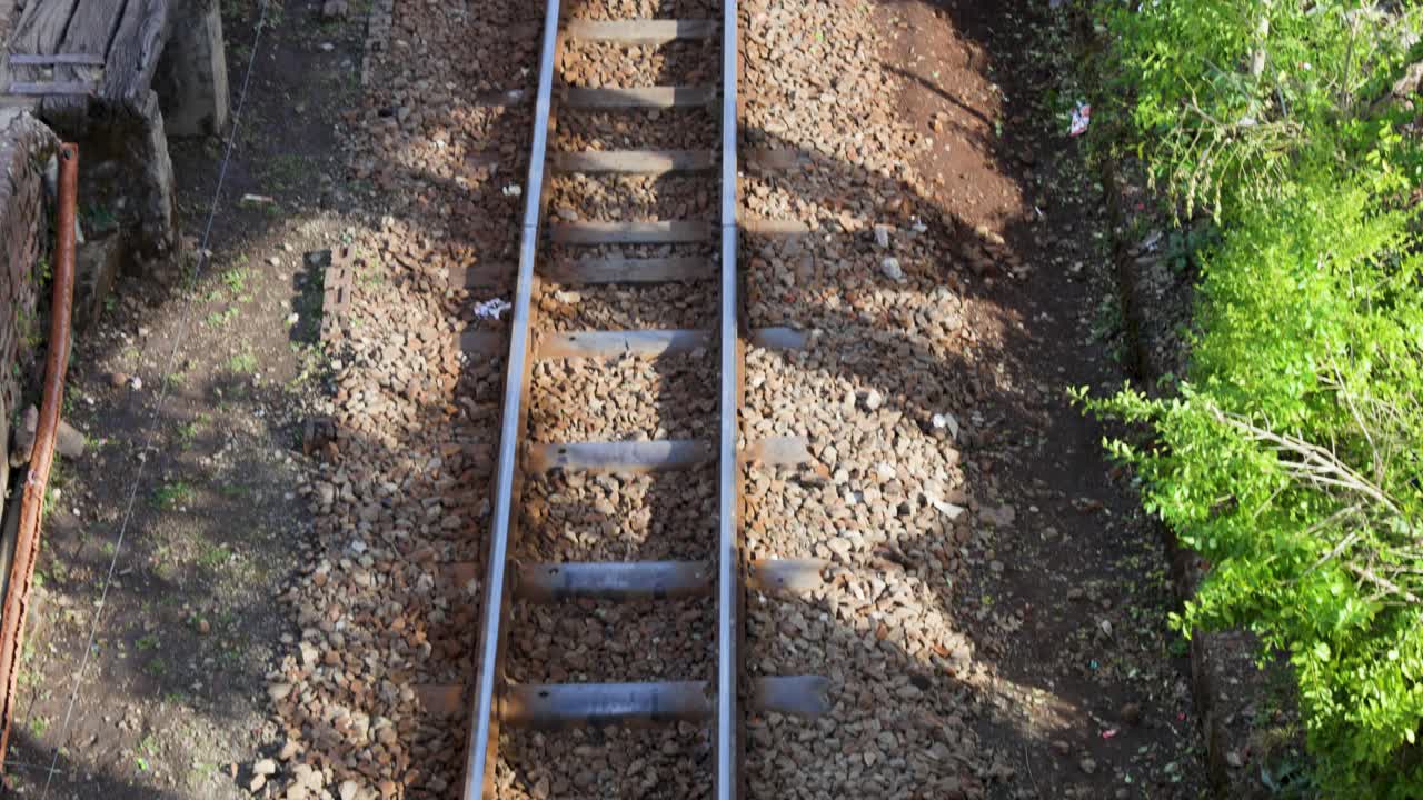 narrow gauge railway track top view with steel rails wooden sleepers and gravel stones
