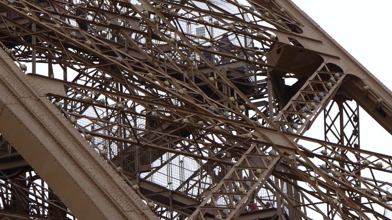 A static low angle shot captures the detailed metal girders and architectural engineering in Paris