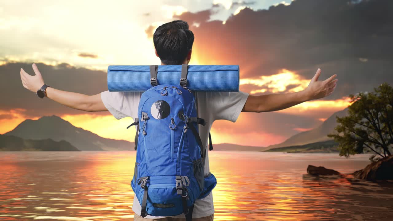 Back View Of A Male Hiker With Mountaineering Backpack Spreading Arms And Looking The View Around At A Lake