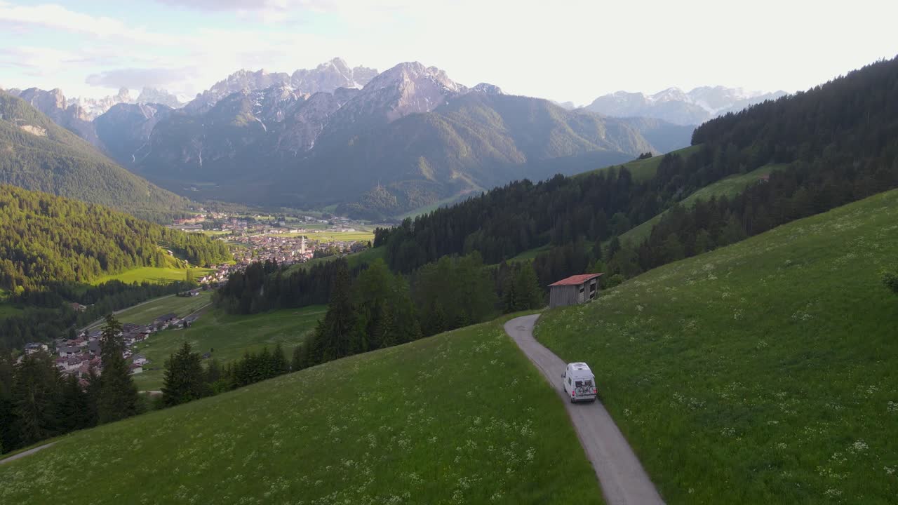 una furgoneta explora las afueras de toblach, italia en esta toma de drone