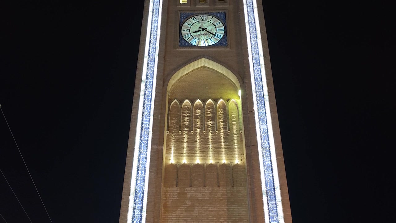 Torre dell'orologio illuminata di notte in stile architettonico tradizionale