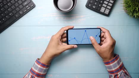 person analyzing data on a smartphone at a desk