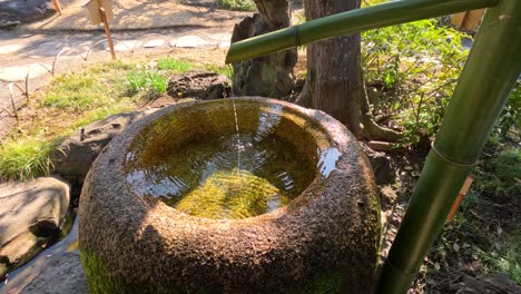 agua que fluye rítmicamente en una cuenca de piedra