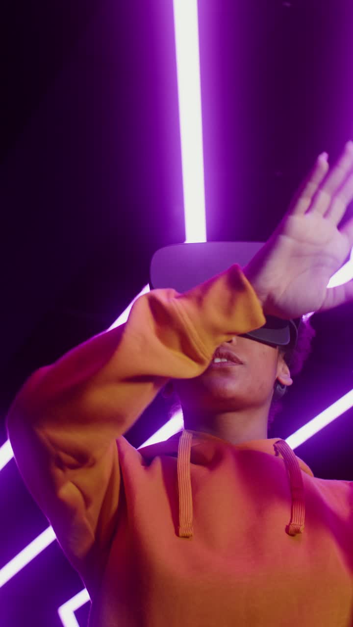 Woman experiencing virtual reality with VR headset in neon light