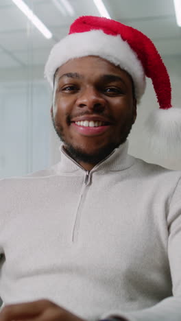 hombre con sombrero de papá noel en la oficina