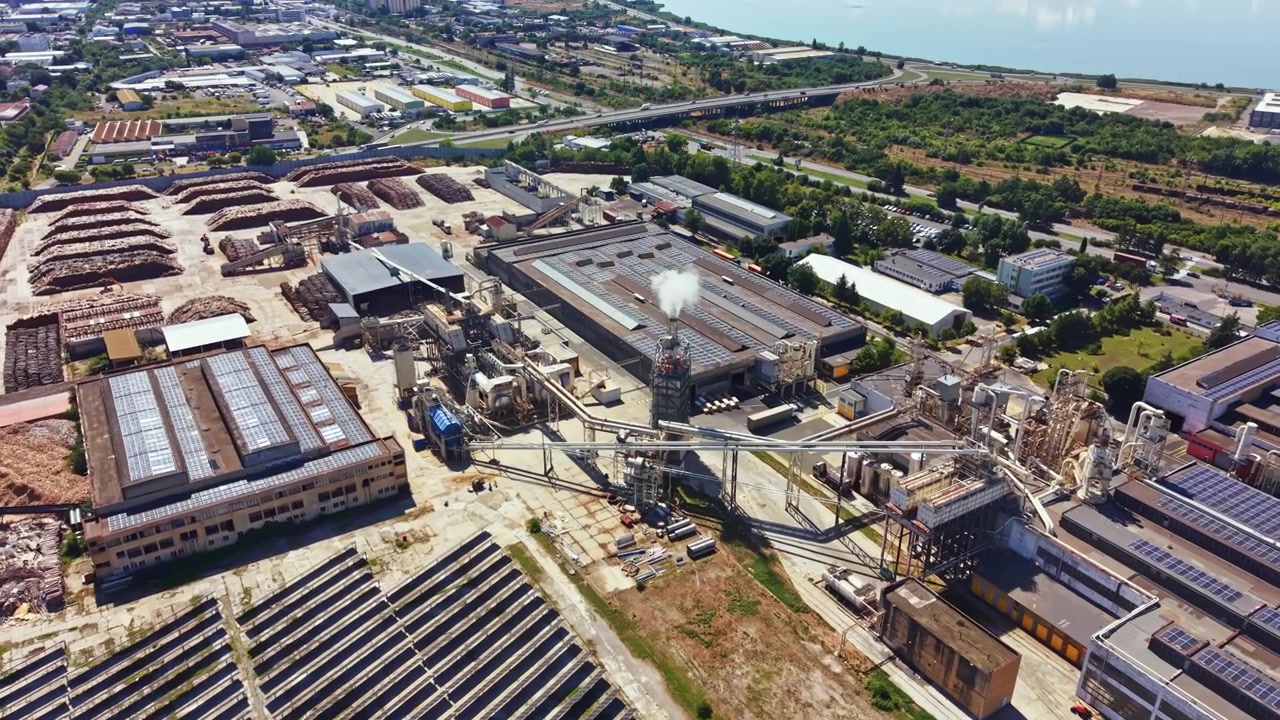 Industrial area with factories and solar panels near waterfront in bright daylight