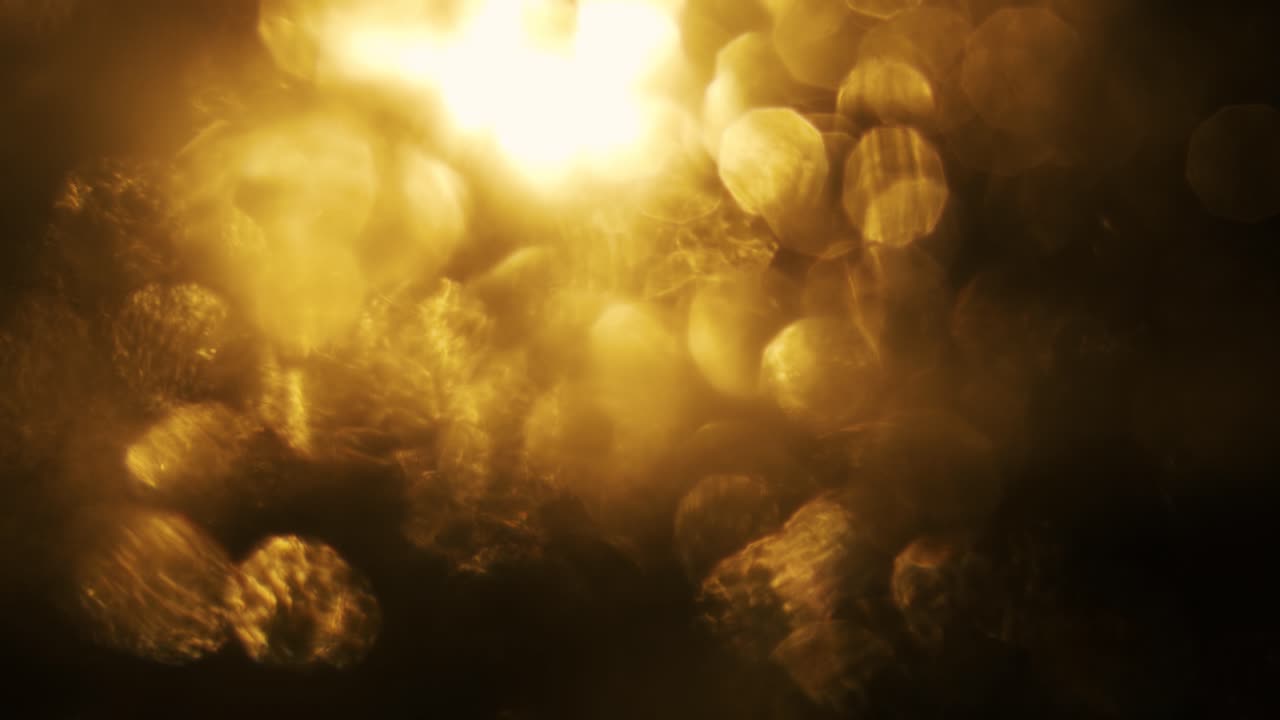 Warme goudkleurige bokeh lichten fonkelend op zwarte achtergrond