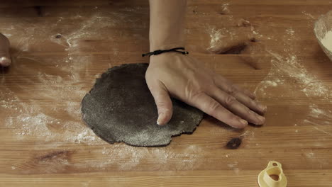 presione las manos el cortador de galletas de navidad en la masa de pan de jengibre, ángulo alto