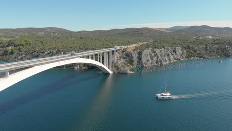 arch traffic bridge connecting the two mountains over the adriatic sea coast, croatia. aerial