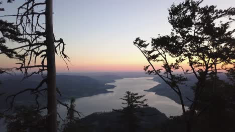 drone fly through trees - reveal austrian lake - sunrise