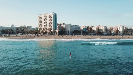 escena de playa en barcelona con stand up paddleboarding